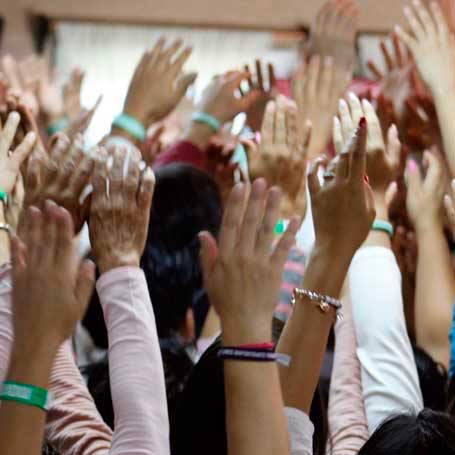 Participantes de evento DEHAC alzando las manos en dinámica